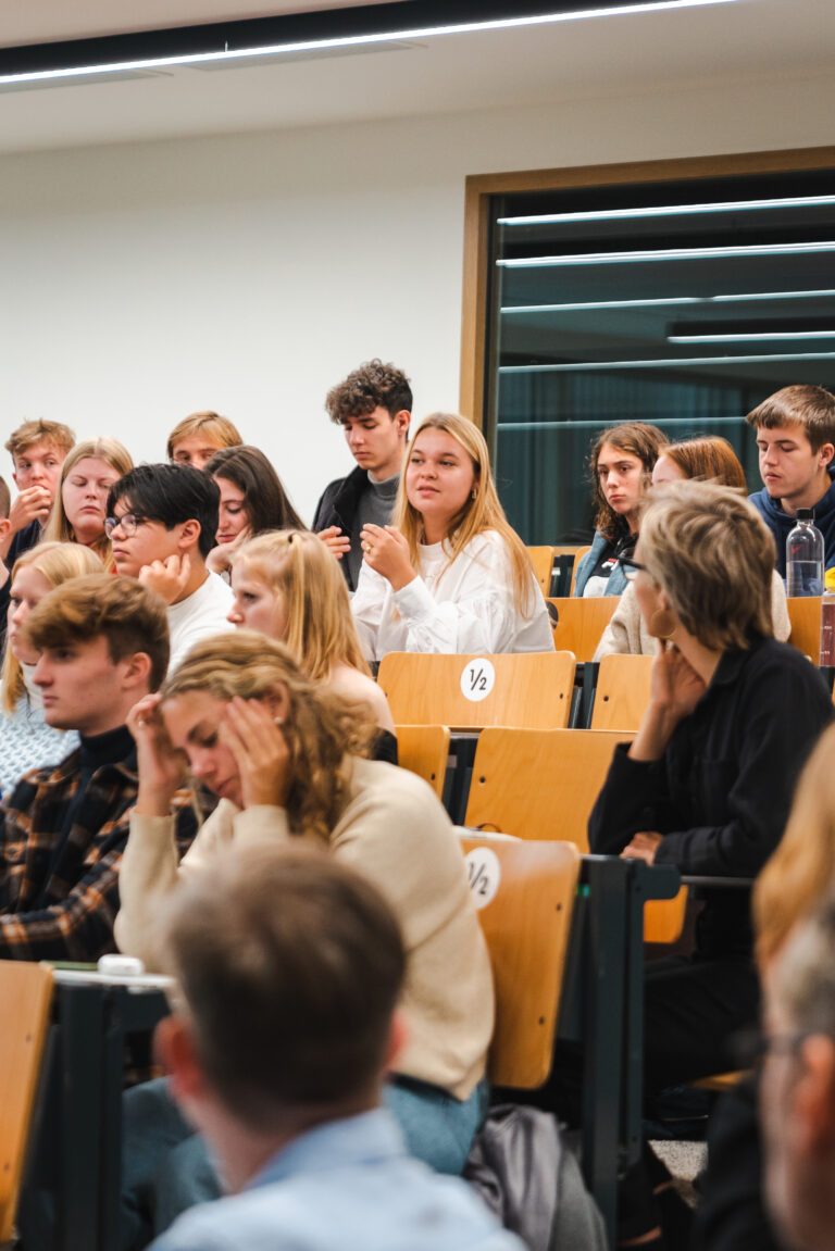 foto van eerstejaars student communicatie manon huyghe die een vraag van de VRT beantwoord in een aula van Howest campus Kortrijk